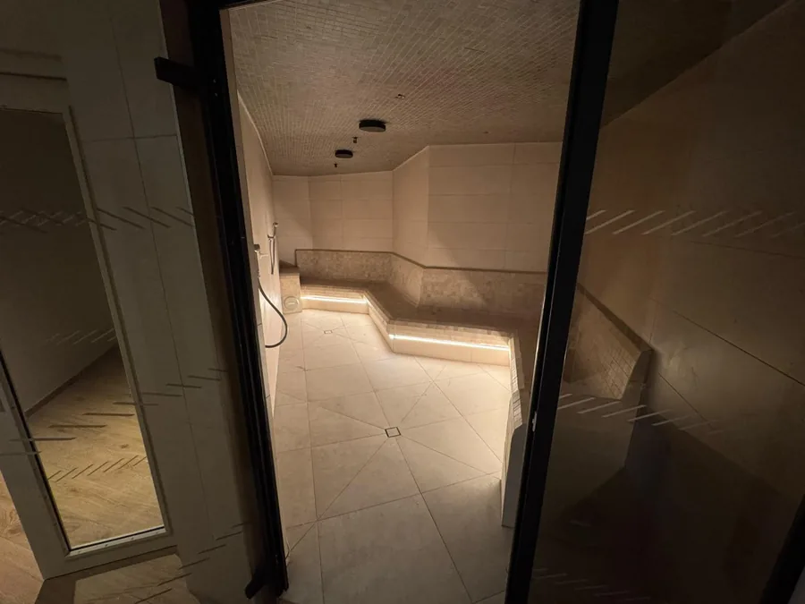 Hammam carrelé avec banquettes et éclairage intégré